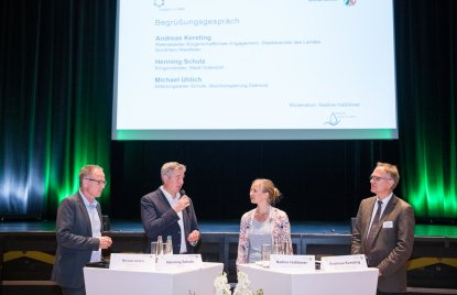 Ein Frau und drei Männer in einer Diskussionsrunde auf einer Bühne. Von links nach rechts: Herr Michael Uhlich, Herr Henning Schulz, Frau Nadine Haßlöwer und Herr Andreas Kersting.