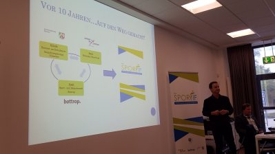 Linksseitig eine Leinwand mit einer Präsentation über den Bottroper Sportbund.