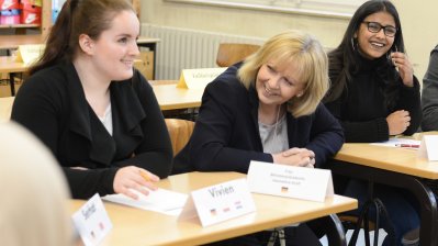 Ministerpräsidentin Hannelore Kraft sitzt zwischen Schülerinnen und Schülern im Klassenraum