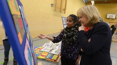 Ministerpräsidentin Hannelore Kraft sieht sich mit einer Schülerin ein Flipchart mit erarbeiteten Themenbildern an