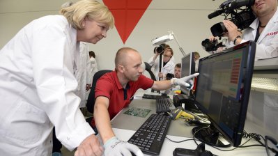 Ein Mitarbeiter zeigt Ministerpräsidentin Kraft etwas auf einem großen PC-Monitor