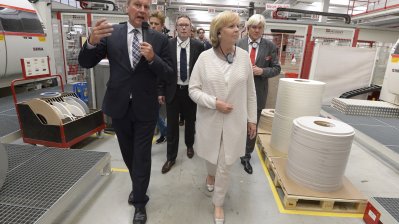 Ministerpräsidentin Kraft läuft durch die Produktionshalle