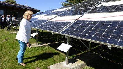 Ministerpräsidentin Hannelore Kraft betrachtet eine Reihe von Solarkollektoren
