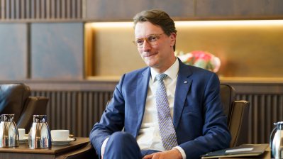 Ministerpräsident Wüst hört dem Botschafter zu