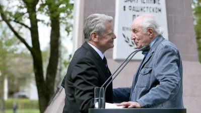Bundespräsident Joachim Gauck hält die Hände des Überlebenden Lev Frankfurt