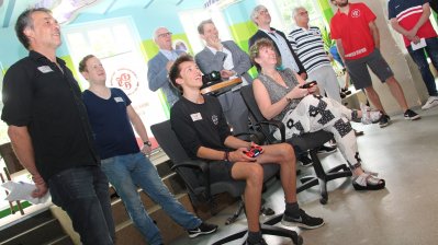 Staatssekretärin Andrea Milz sitzt auf einem Büro-Drehstuhl und schaut einem Vorstellung zu.