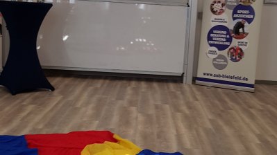 Auf einem großem Bildschirm läuft die Präsentation des Stadtsportbunds Bielefeld e.V.