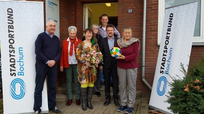 Staatssekretärin Andrea Milz mit den Vorstandsmitgliedern des Sportbunds Bochum vor dem Vereinsgebäude.