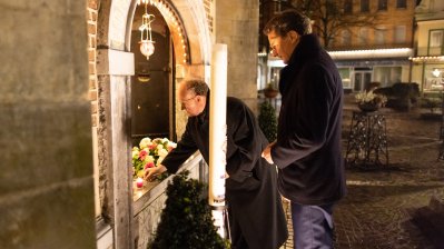 Anzünden einer Kerze vor der Kirche