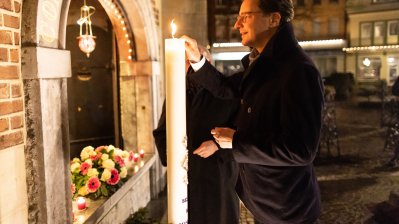 Anzünden einer Kerze vor der Kirche