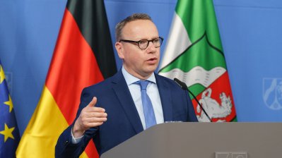 Eine Person spricht am Rednerpult auf einer Pressekonferenz