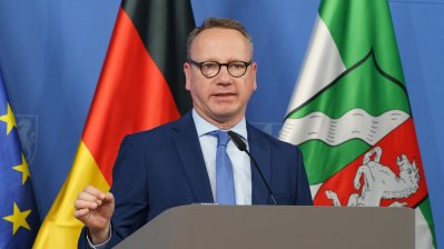 Eine Person spricht am Rednerpult auf einer Pressekonferenz