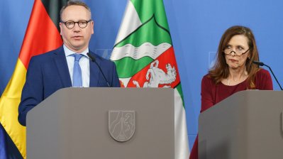 Eine Person spricht am Rednerpult auf einer Pressekonferenz