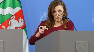 Eine Person spricht am Rednerpult auf einer Pressekonferenz