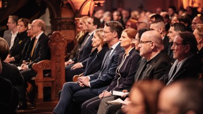 MP Wüst und Gäste sitzen im Publikum