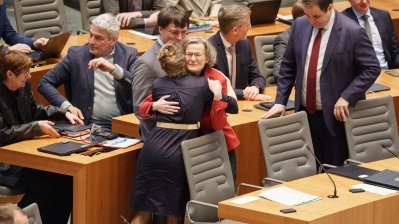 Ministerin Schäffer wird von Kabinettmitgliedern auf der Regierungsbank umarmt