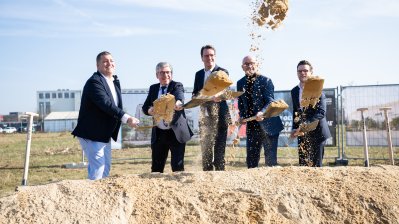 Eine Personengruppe posiert beim Spatenstich