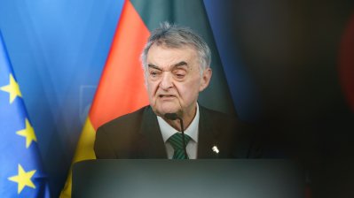 Minister Reul spricht an einem Rednerpult vor Flaggen