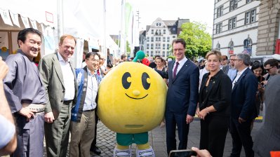 MP Wüst, der Düssledorfer OB Keller und weitere Personen posieren neben einem riesigen Pac-Man für ein Foto