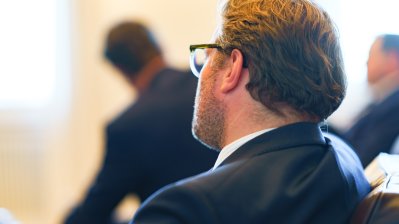 Besprechungssituation in einem festlichen Raum, Staatssekretär Wiermer hört zu