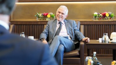 Besprechungssituation in einem festlichen Raum, der Doyen lacht