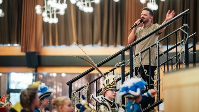 Ein Sänger steht auf einer Treppe vor der Bühne