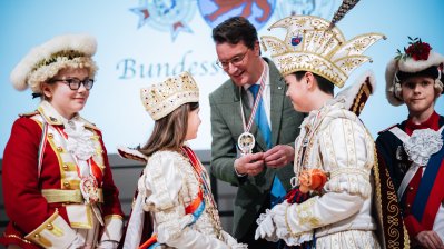Ministerpräsident Hendrik Wüst überreicht den Karnevalsorden auf der Bühne