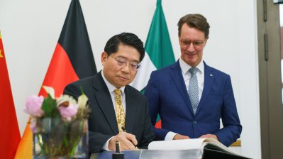 Der Botschafter trägt sich in das Gästebuch der Landesregierung ein