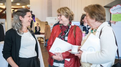 Drei Damen stehend im Gespräch.