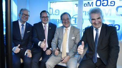 Die PErsonen sitzen auf einer Sitzbank im Bus und halten die Daumen hoch