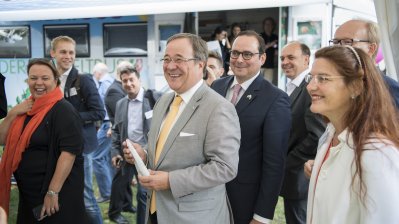 Ministerpräsident Armin Laschet und Umweltministerin Ursula Heinen-Esser stehen an einem Stand und lachen