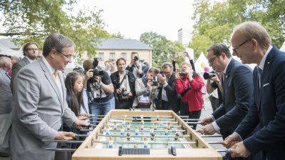 Ministerpräsident Armin Laschet und ein Mädchen spielen Kicker gegen den Essener Oberbürgermeister Thomas Kufen und Landtagspräsident André Kuper 