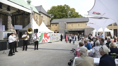 Musiker vor eine Bühne und Passanten