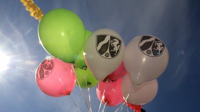 Das Bild zeigt bunte Luftballons mit NRW-Wappen.