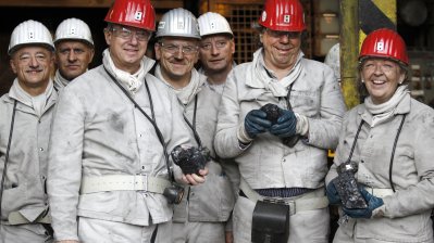 Gruppenfoto mit Ministerpräsidentin Kraft (rechts), Botschafter Emerson (2. von links) und Ruhrtriennale-Intendant Simons (2. von rechts) im Rahmen der Grubenfahrt im Bergwerk Auguste Victoria.