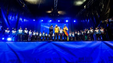 Eröffnungsfeier auf einer blauen Bühne.