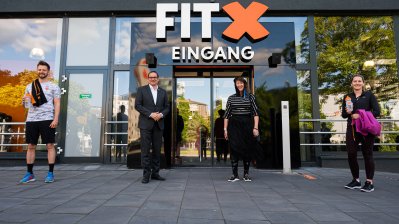 Staatssekretärin Milz vor einem Fitness-Studio-Eingang.