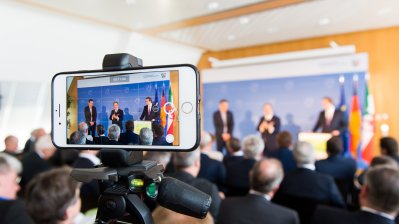 Pressekonferenz Olympiabewerbung aus der Sicht eines Smartphones.