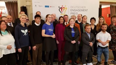 Staatssekretärin Andrea Milz steht rechts neben der Gruppe von Engagementpreisträgern.