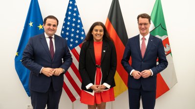 Die Generalkonsulin steht neben dem Ministerpräsidenten und dem Minister Liminski vor den Flaggen der EU, USA, Deutschlands und des Landes Nordrhein-Westfalens.