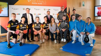 Ministerpräsident Armin Laschet steht mit einem Tischtennisspieler-Team zusammen für ein Portraitbild.