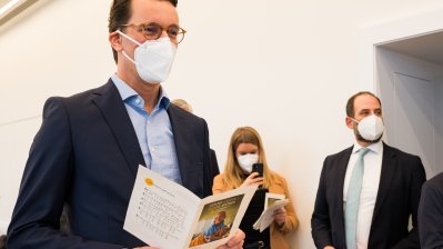 Ministerpräsident Hendrik Wüst schaut in das Gesangsheft