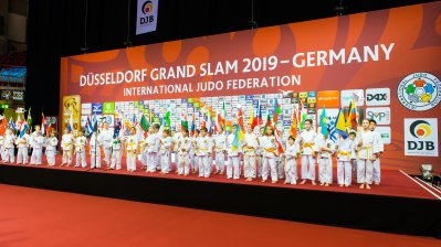 Kinder-Judokas stehen in einer Reihe nebeneinander auf der Bühne.