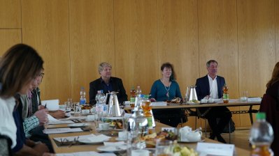 Großaufnahme von Staatssekretärin Andrea Milz mit anderen Teilnehmern in einer Konferenzrunde.