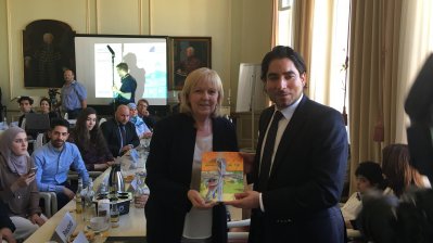 Ministerpräsidentin Kraft und Prof. Mouhanad Khorchide, Leiter des ZIT, halten ein Buch-Geschenk in der Hand und schauen in die Kamera