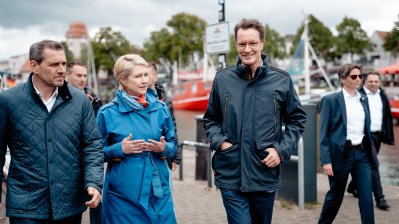 Ministerpräsident Wüst und Ministerpräsidentin Schwesig laufen am Hafen entlang