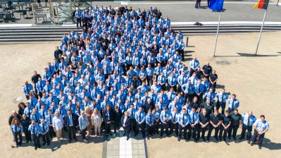 Ein Gruppenfoto aus der Vogelperspektive von den Absolventinnen und Absolventen in blauen Uniformen