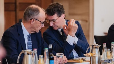 Bundeskanzler Merz und Ministerpräsident Hendrik Wüst sind vertieft in einem Gespräch