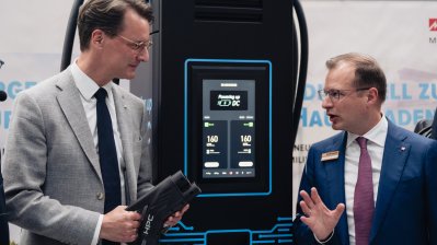 Ministerpräsident Wüst steht an einer Zapfsäule im Gespräch mit einem Mitarbeiter