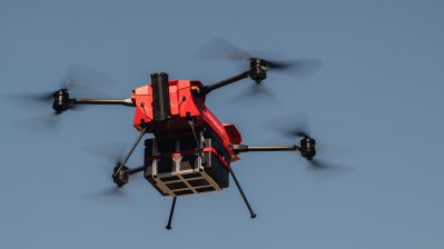 Eine mit einer Lieferung beladene Drohne fliegt in der Luft